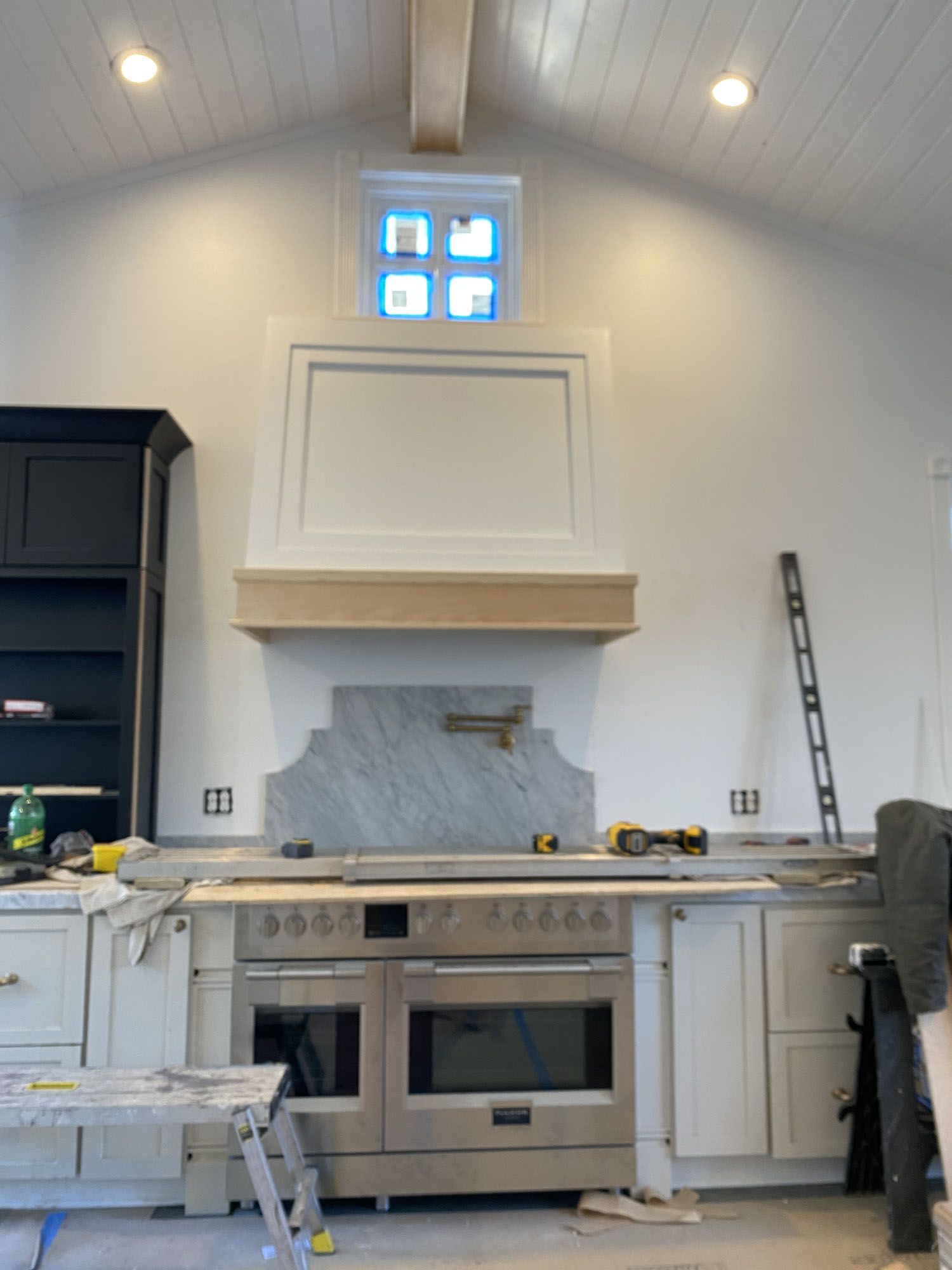 A kitchen with a stove and a window above it