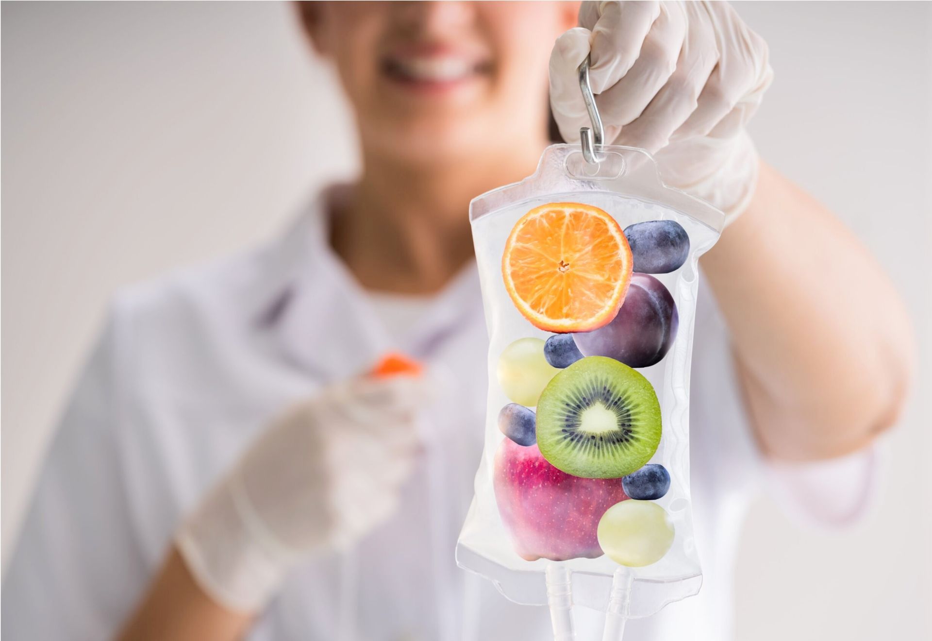 Person in gloves holding IV bag filled with fruit.
