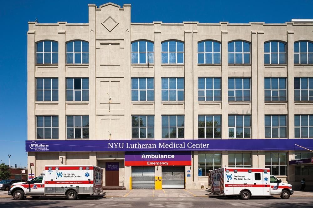 Two ambulances are parked in front of a nyu lawrence medical center