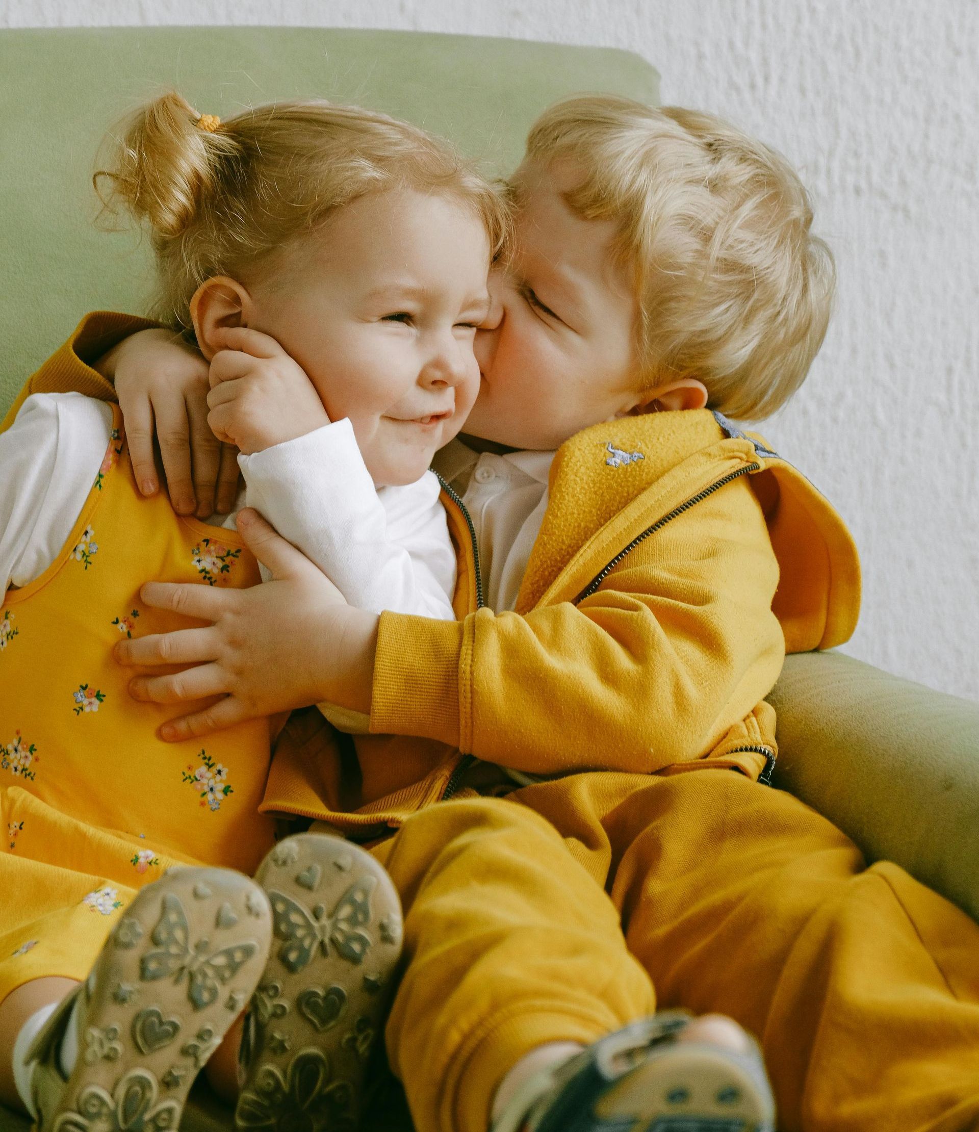 A boy kisses a little girl on the cheek