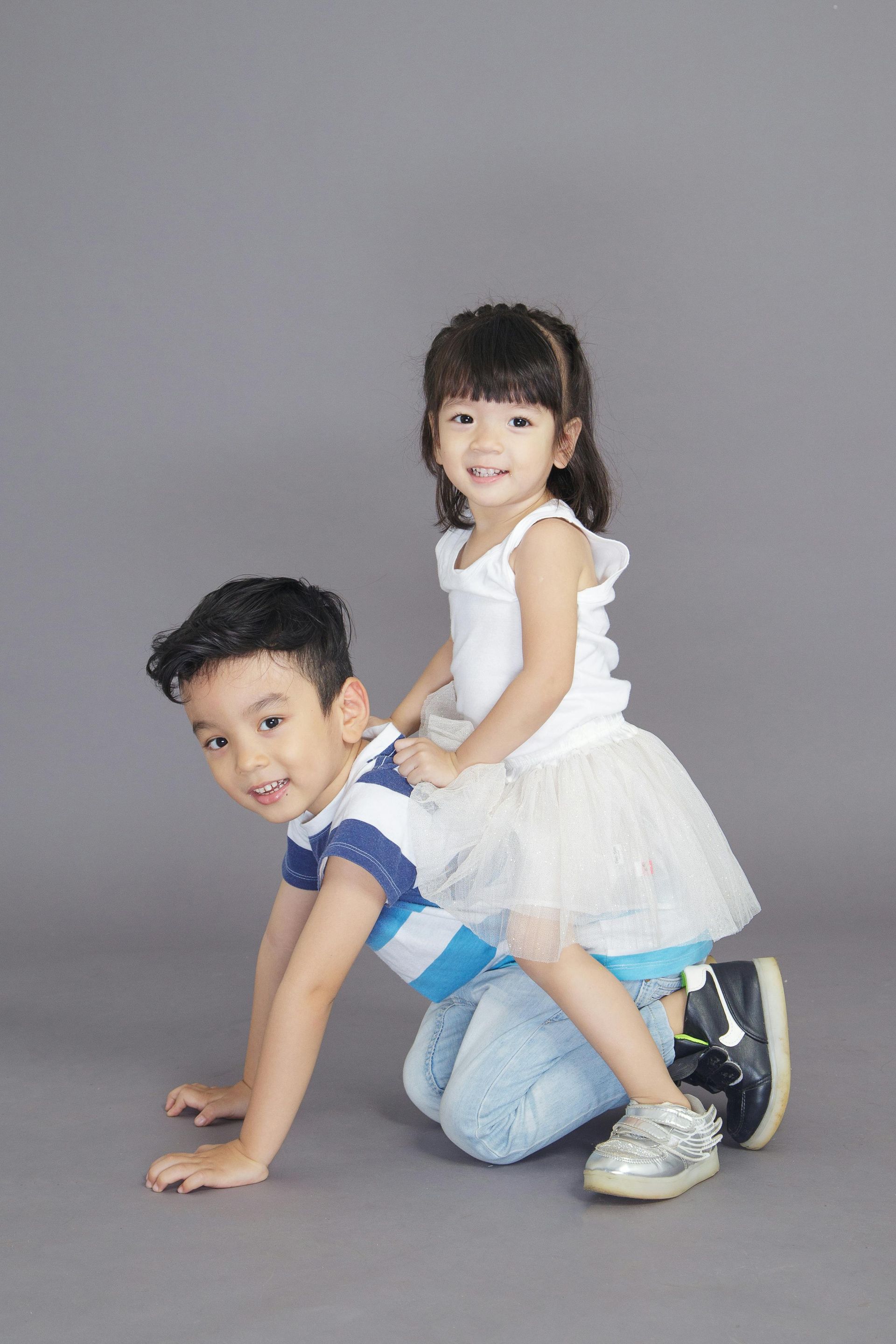 A boy and a girl are playing together on the floor.