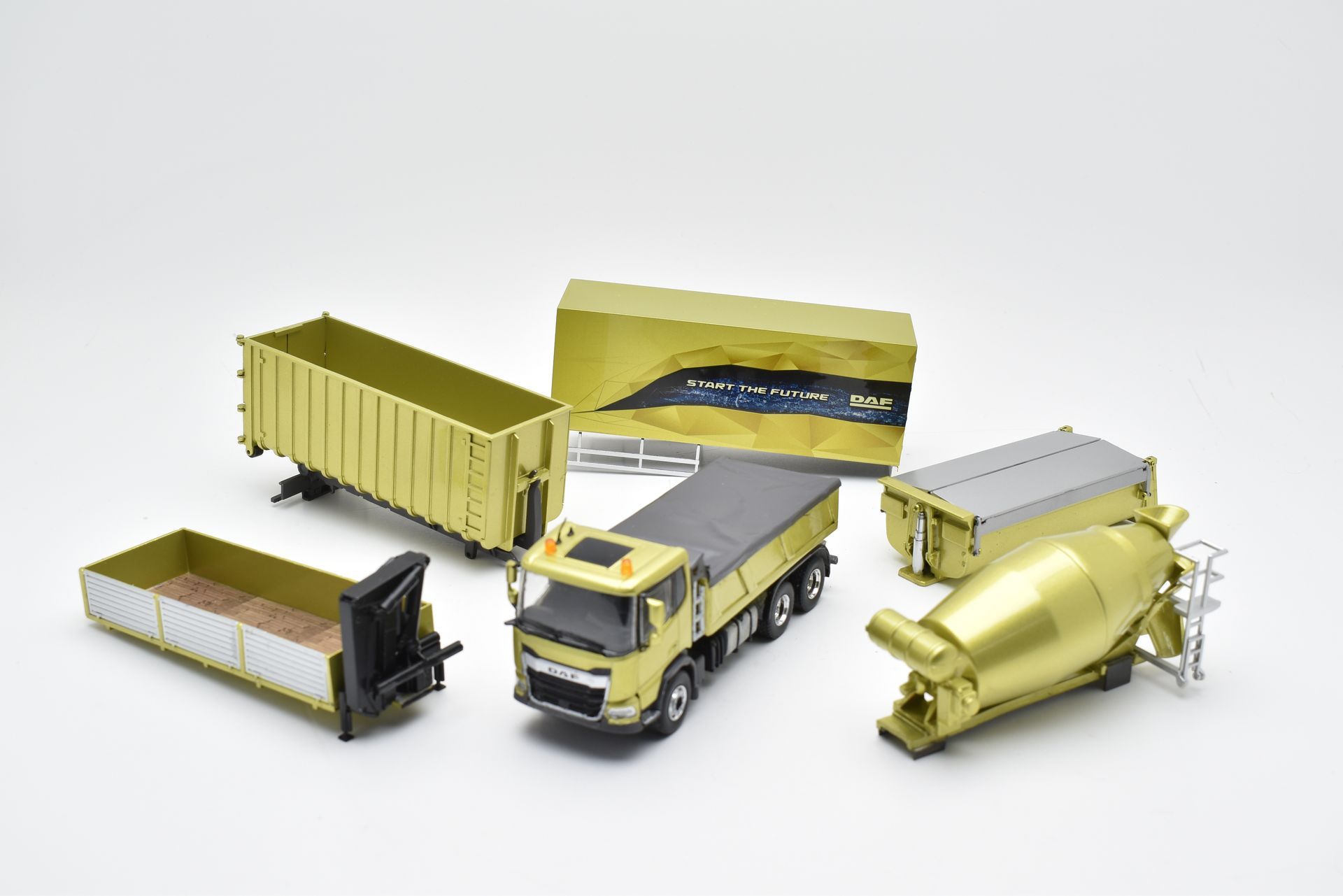 Speelgoedbouwvoertuigen op een witte achtergrond. Inclusief kiepwagen, cementmolen en vrachtcontainers.