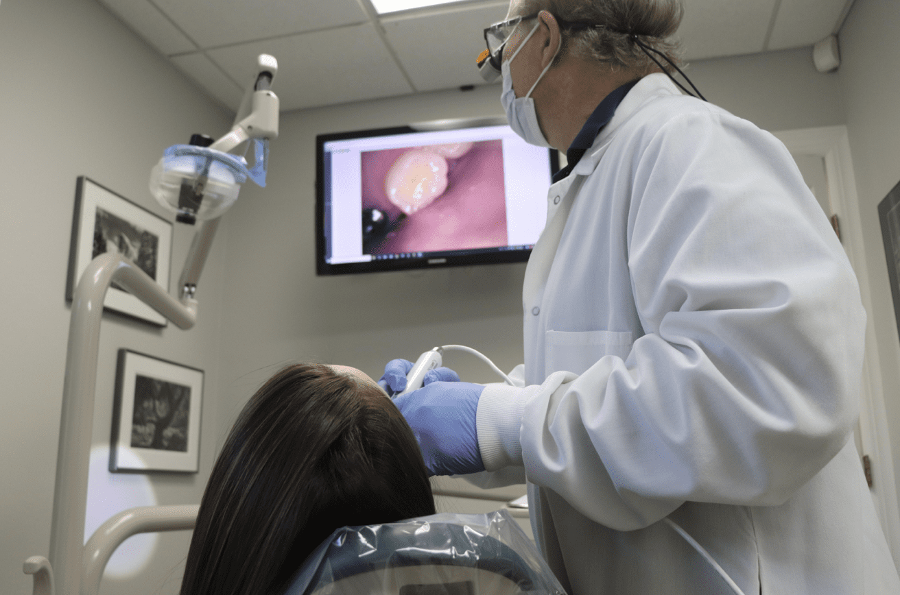 A dentist is examining a patient 's teeth in a dental office