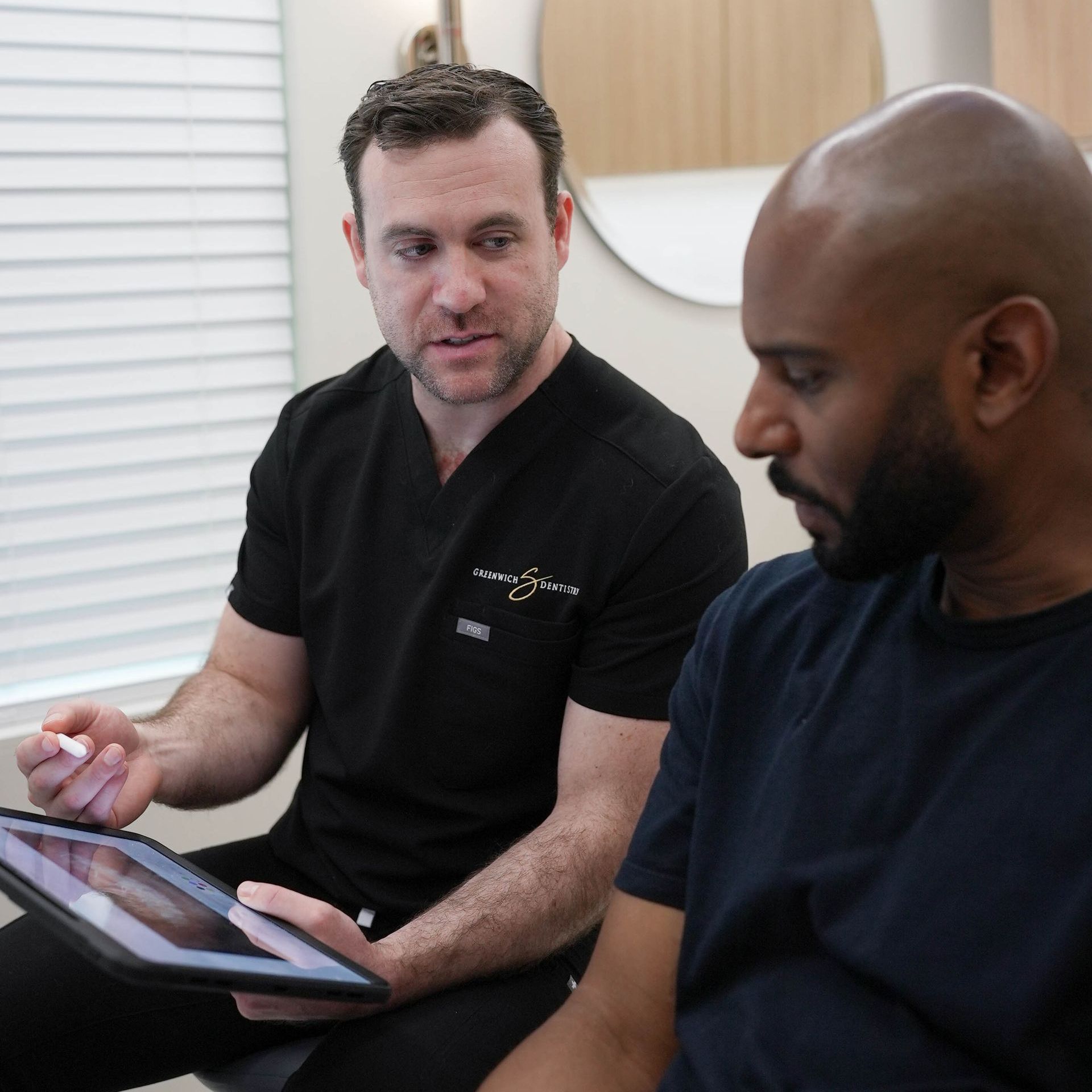 Two men are looking at a tablet together