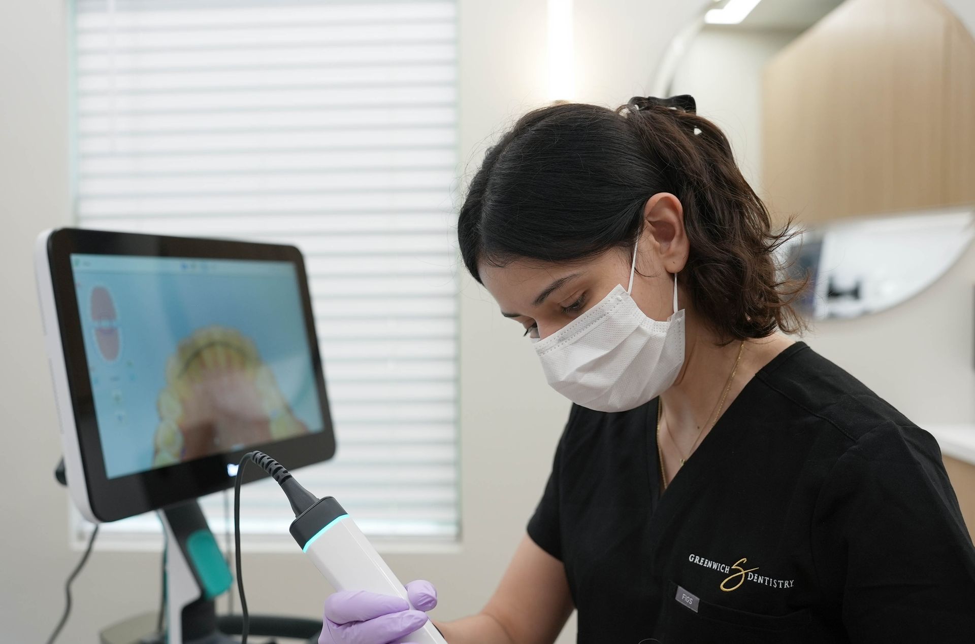 A woman wearing a mask and gloves is using a machine.