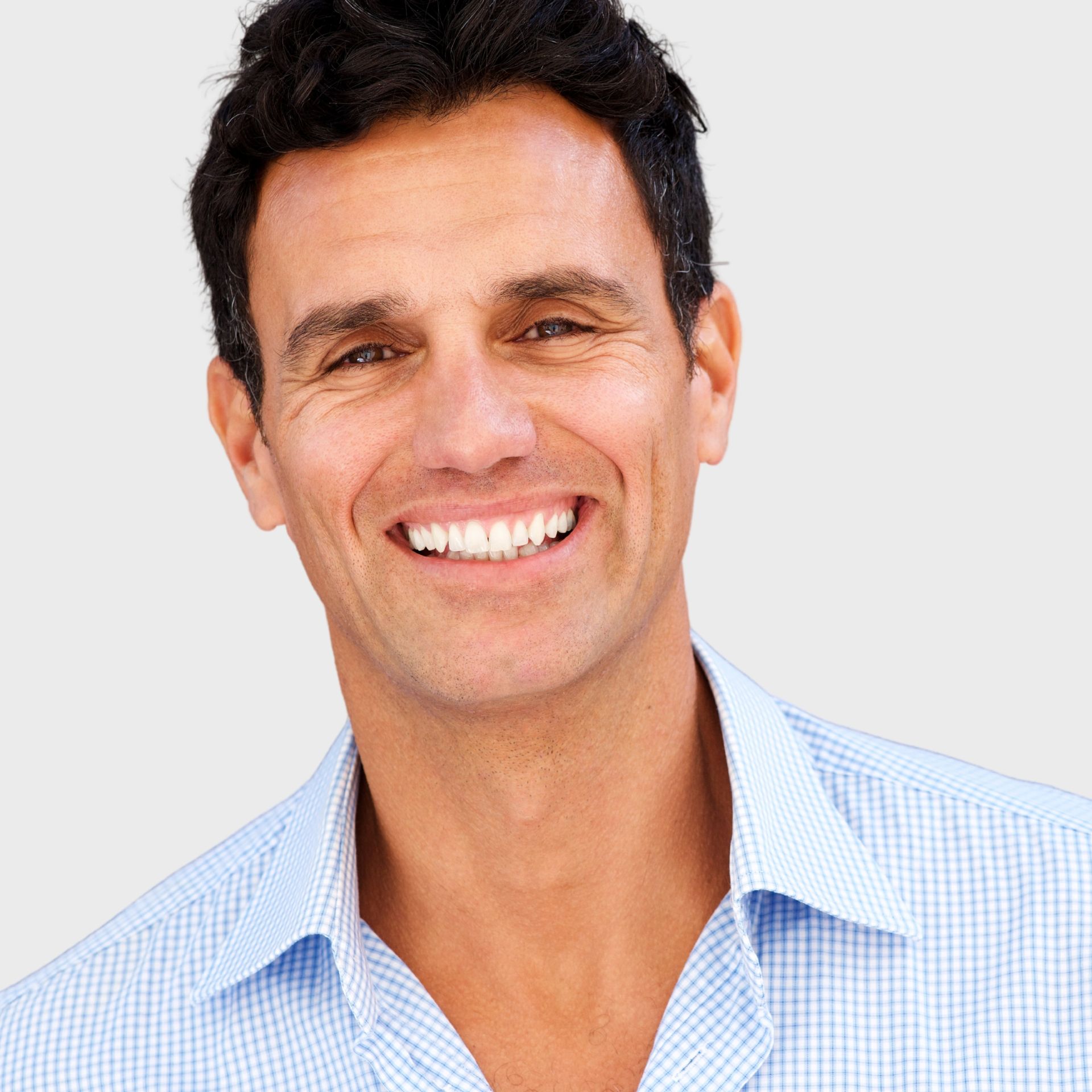 A man in a blue shirt is smiling for the camera
