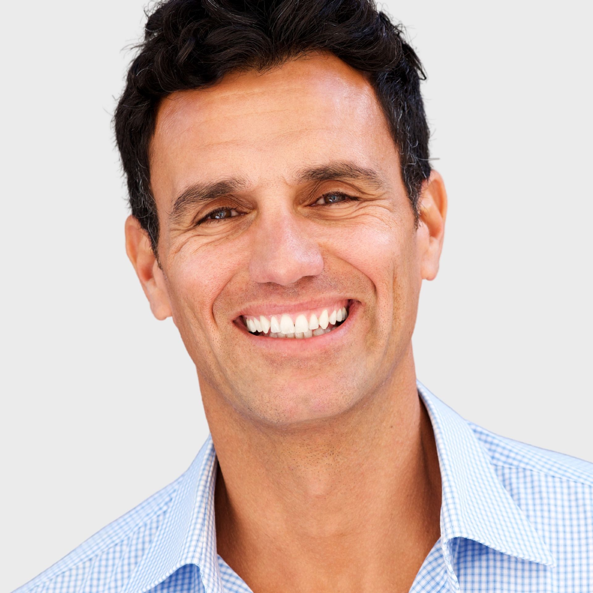 A man in a blue shirt is smiling for the camera
