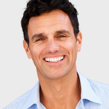 A man in a blue shirt is smiling for the camera
