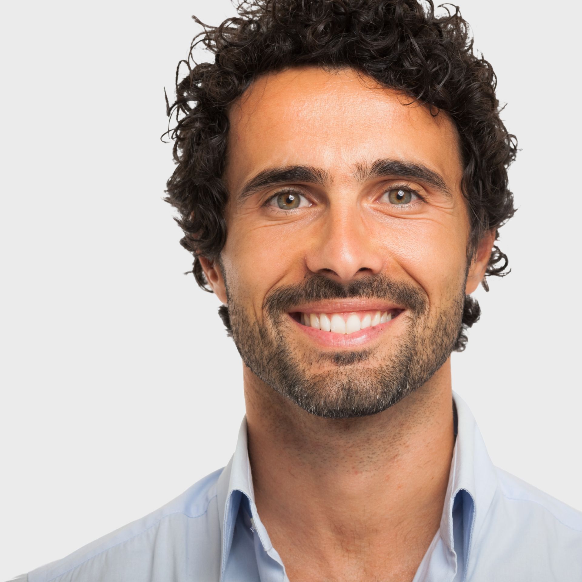 A man with curly hair and a beard smiles for the camera