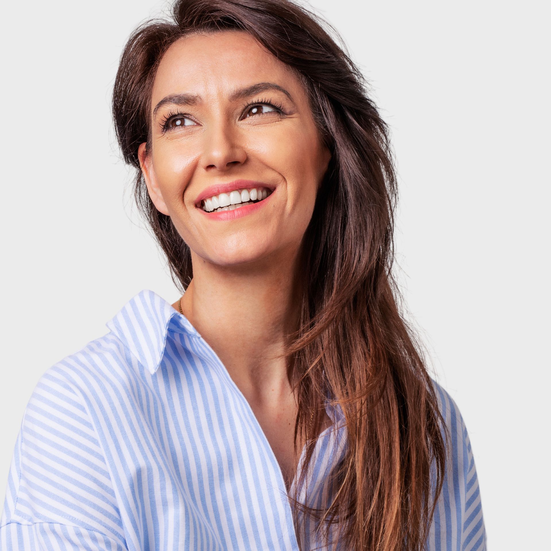A woman wearing a blue and white striped shirt is smiling