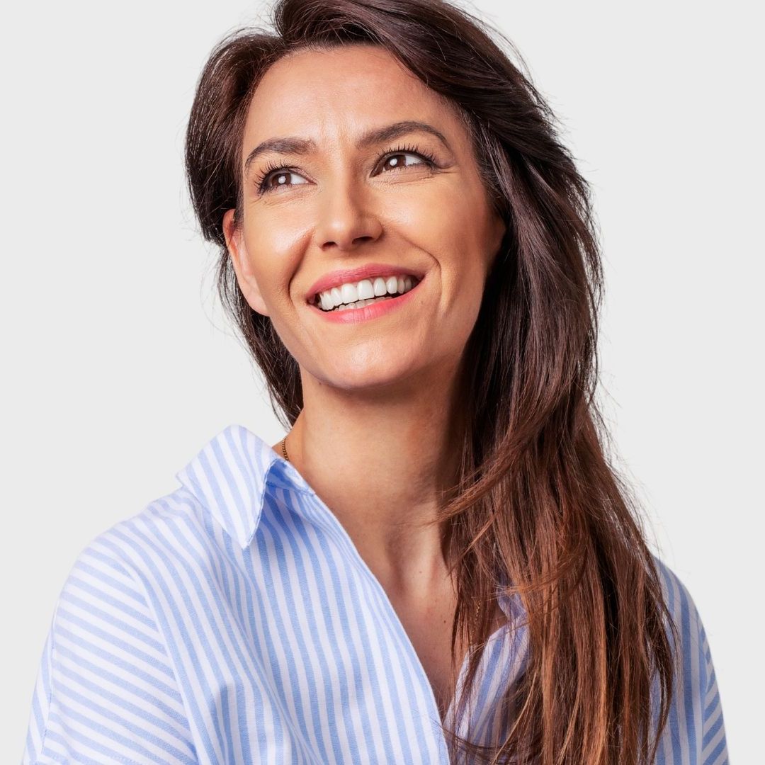 A woman wearing a blue and white striped shirt is smiling