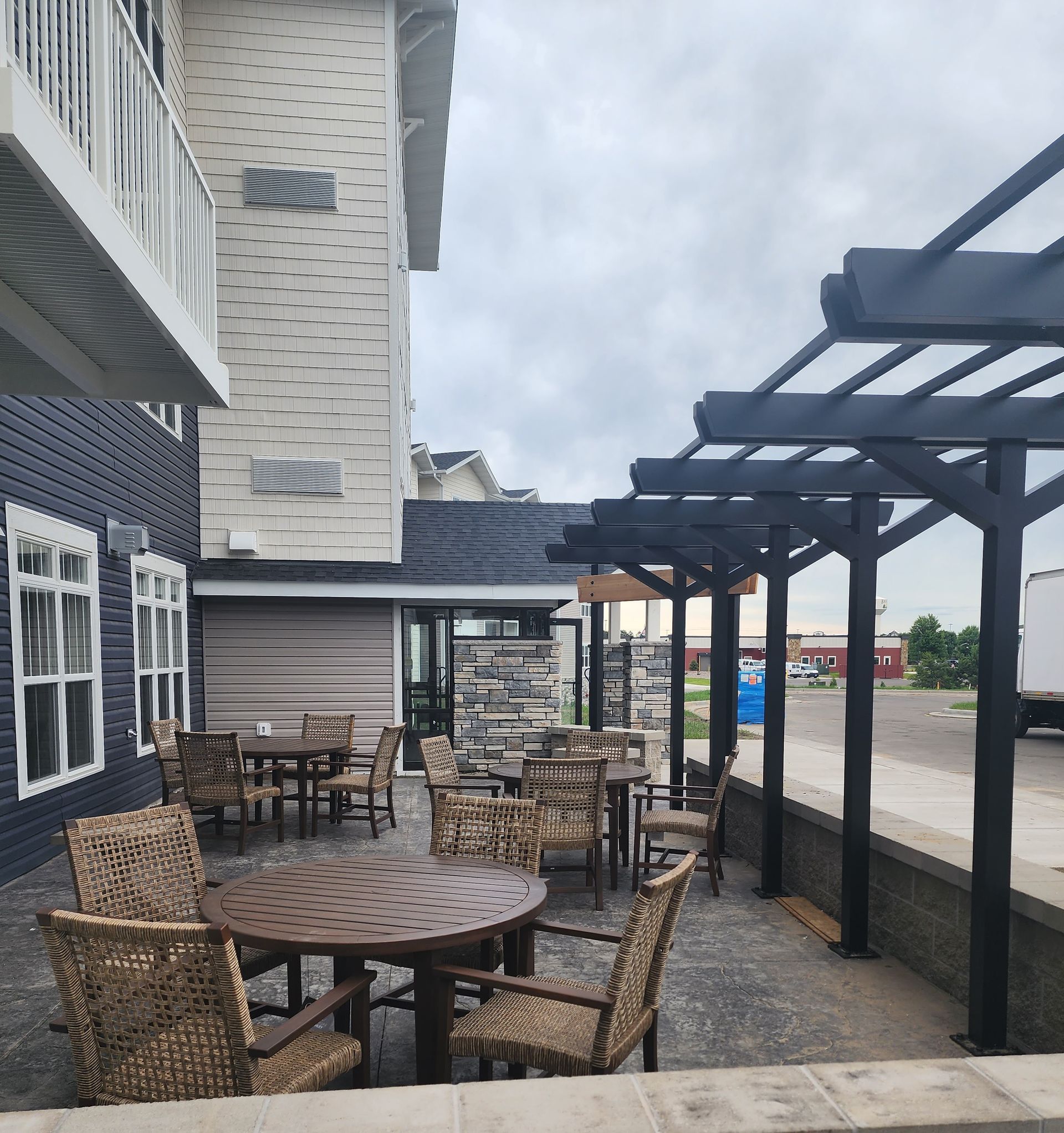 A patio area with tables and chairs under a pergola