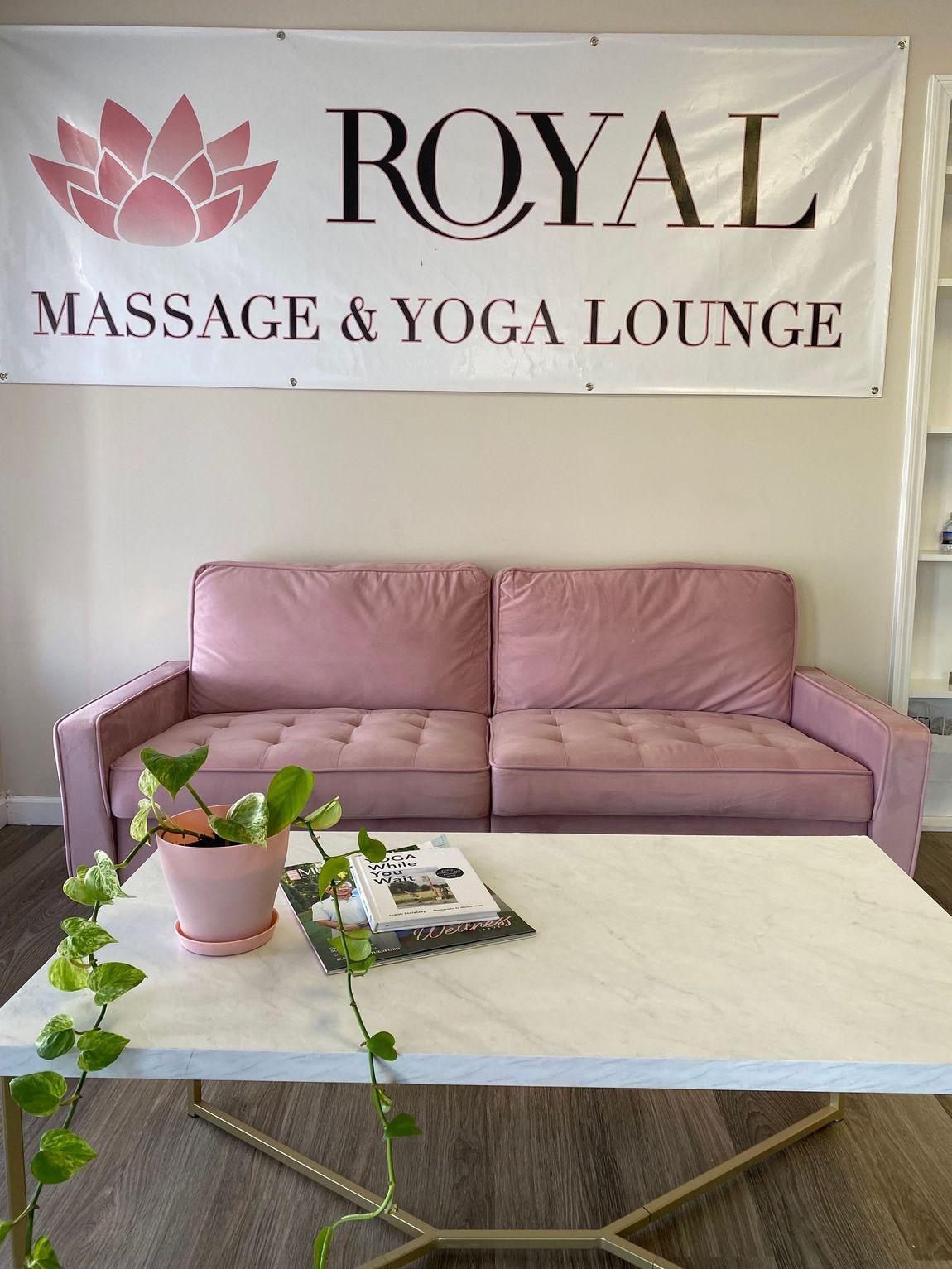 A pink couch in front of a white 