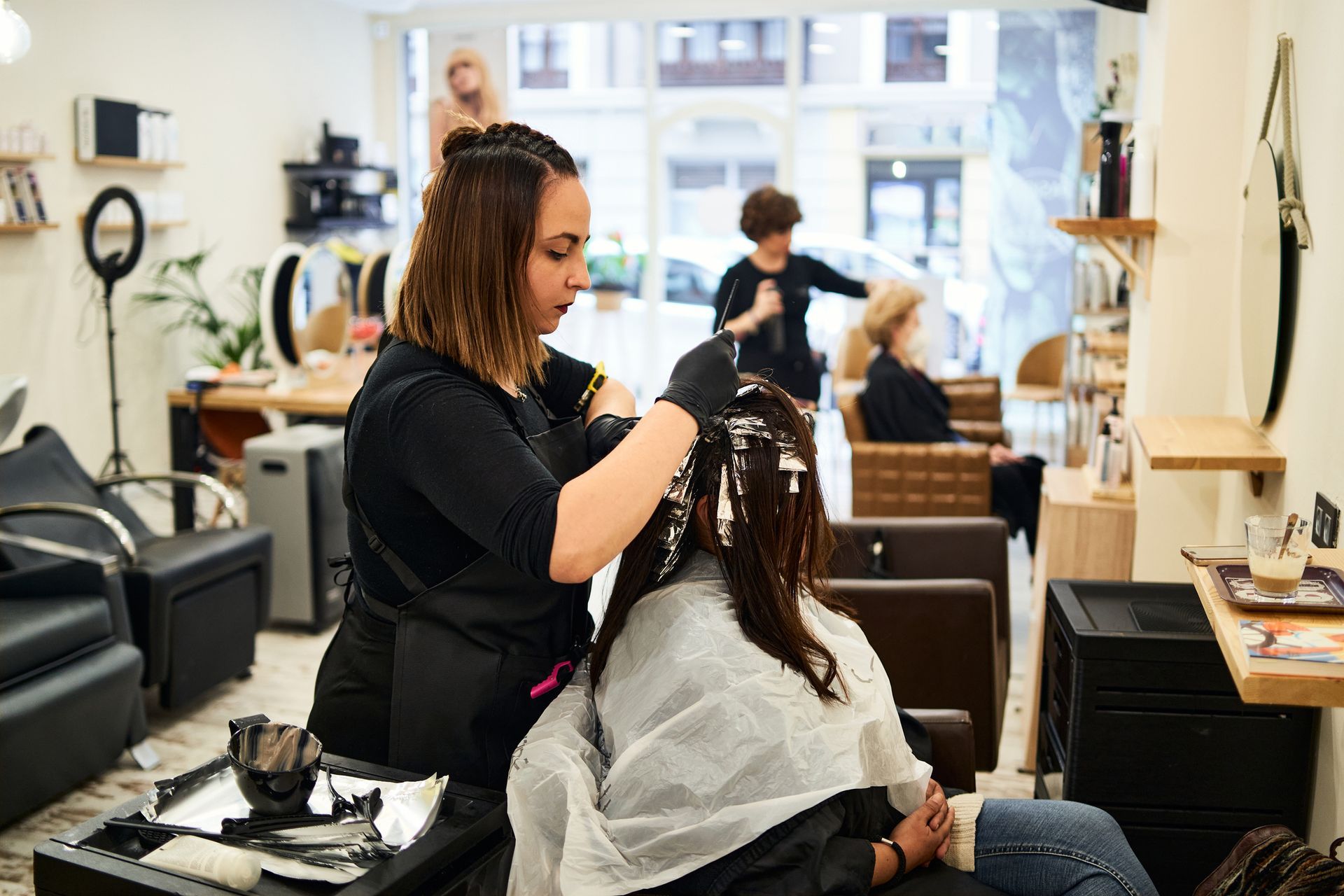 A woman is getting her hair dyed in a salon.