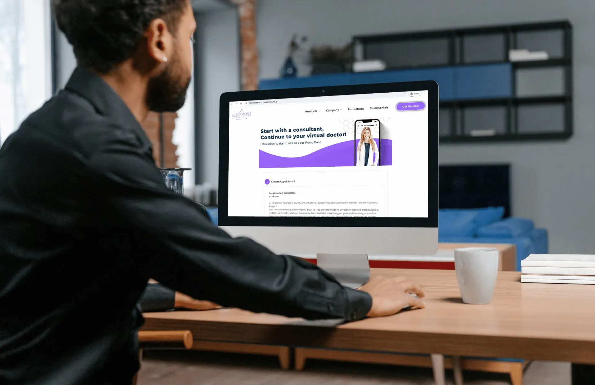 A man is sitting at a desk looking at the Hormone Fitness schedule to qualify for GLP-1 medications.