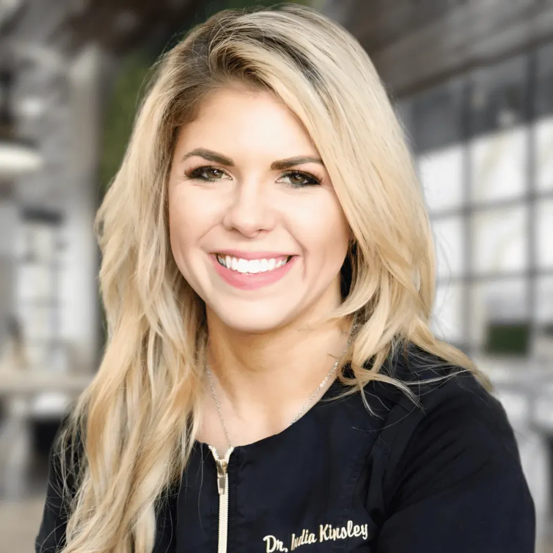 A woman in a black shirt is smiling for the camera.