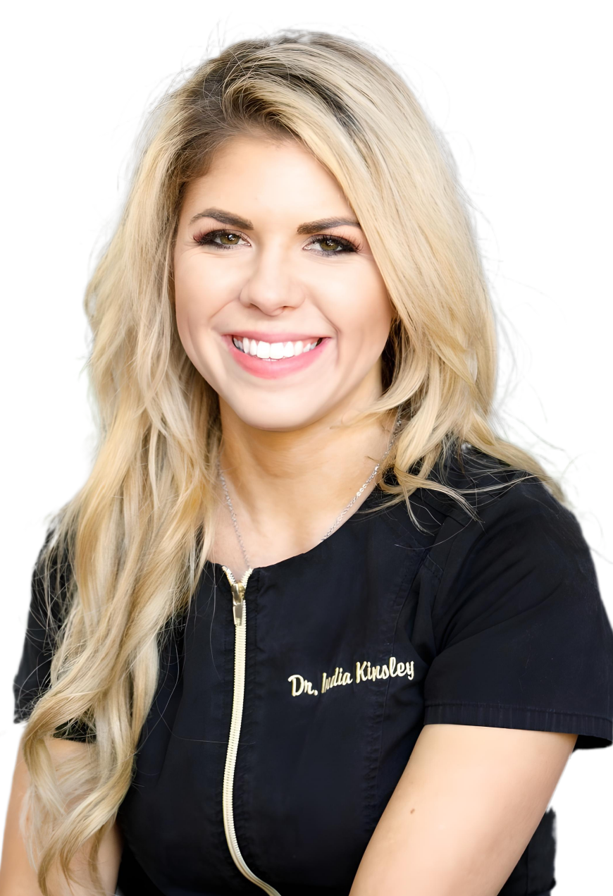 A portrait of Dr. India Hanley, a woman with blonde hair is wearing a black shirt and smiling on a transparent background.