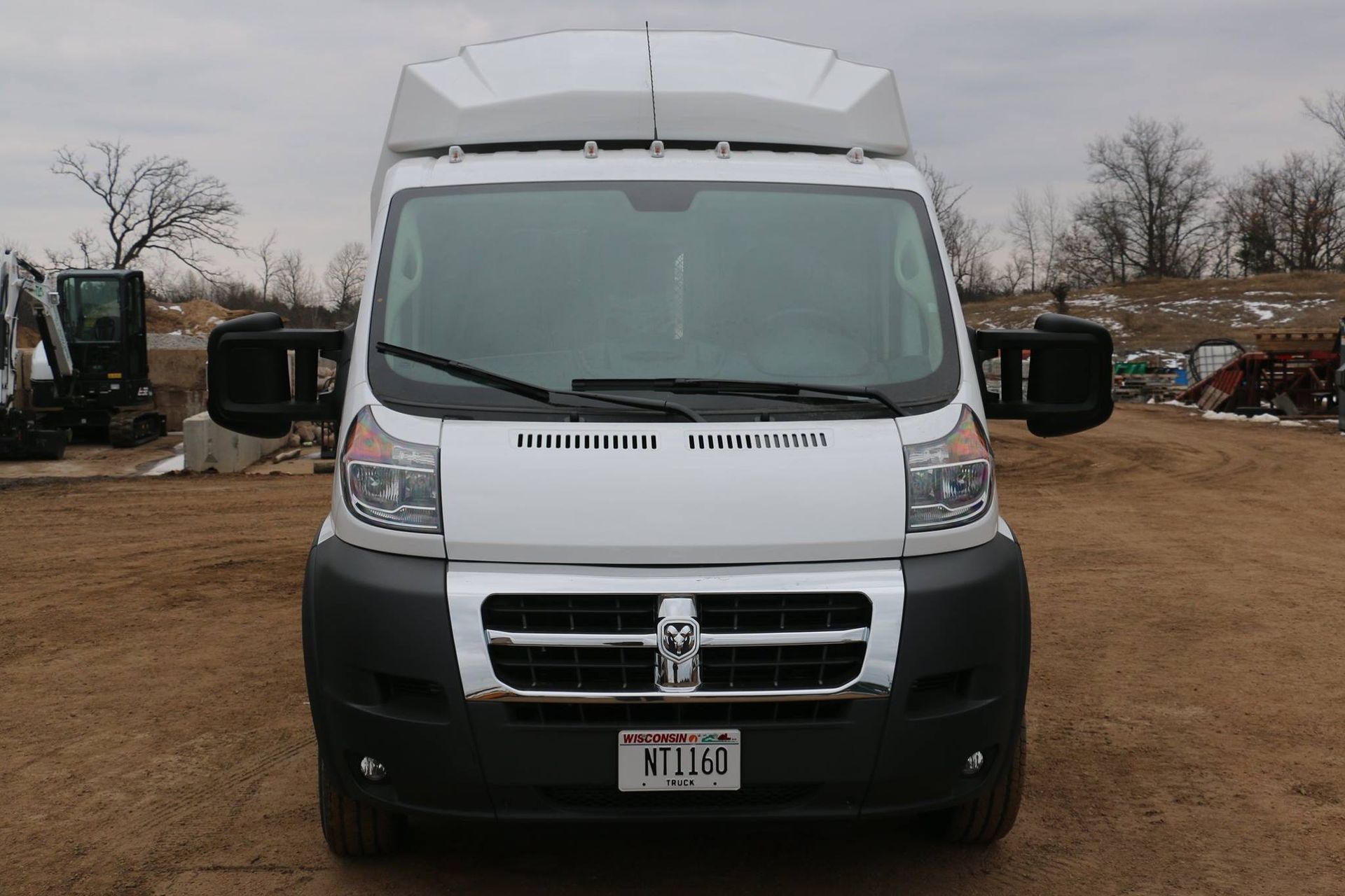 White Dodge ProMaster van with a black bumper, parked outside.