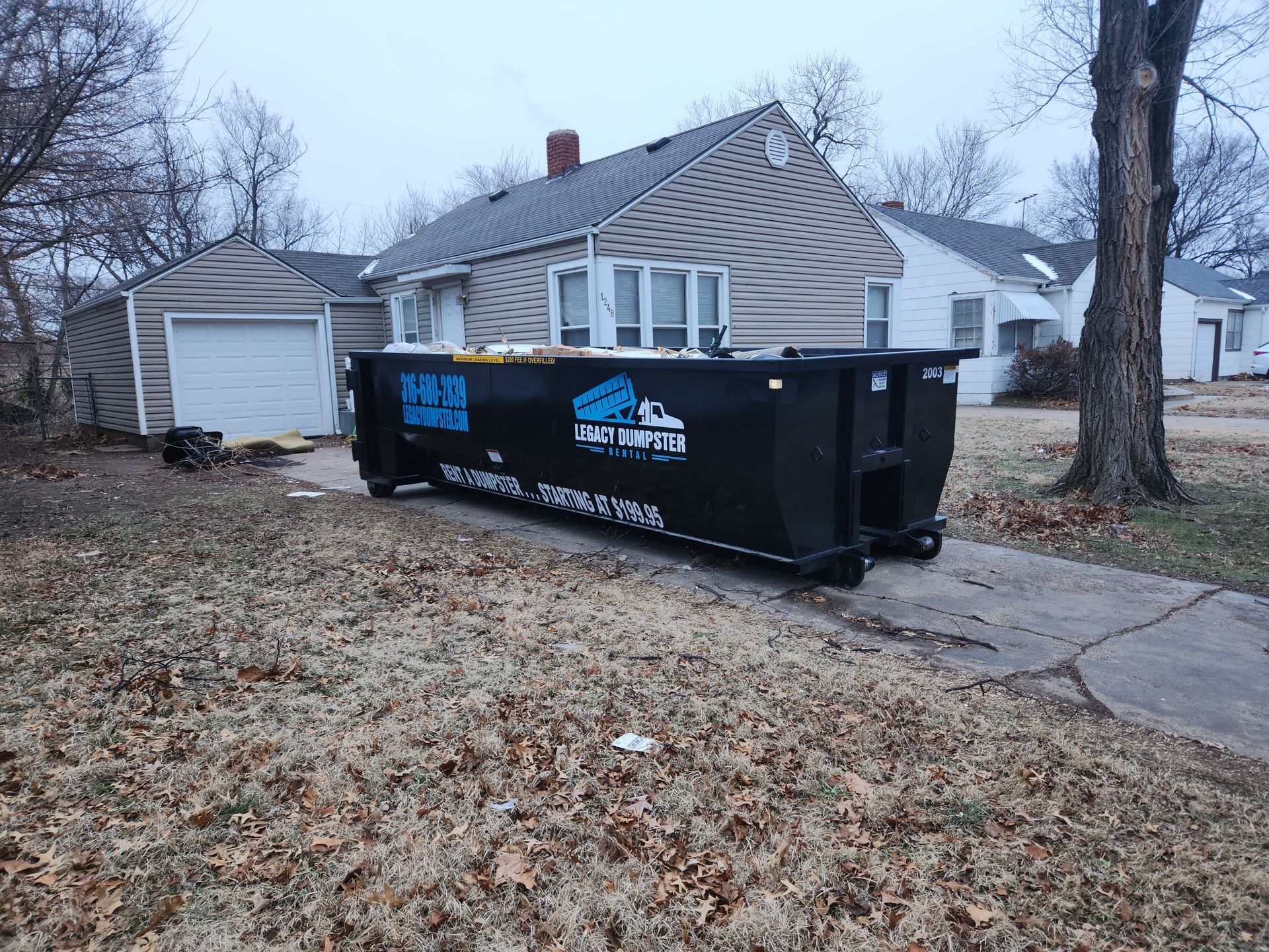A dumpster is parked in front of a house.