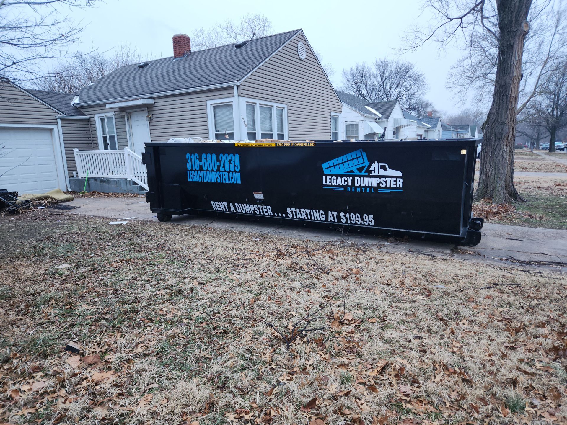 A dumpster is parked in front of a house.