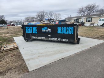 A 20 yard dumpster is sitting on a concrete platform