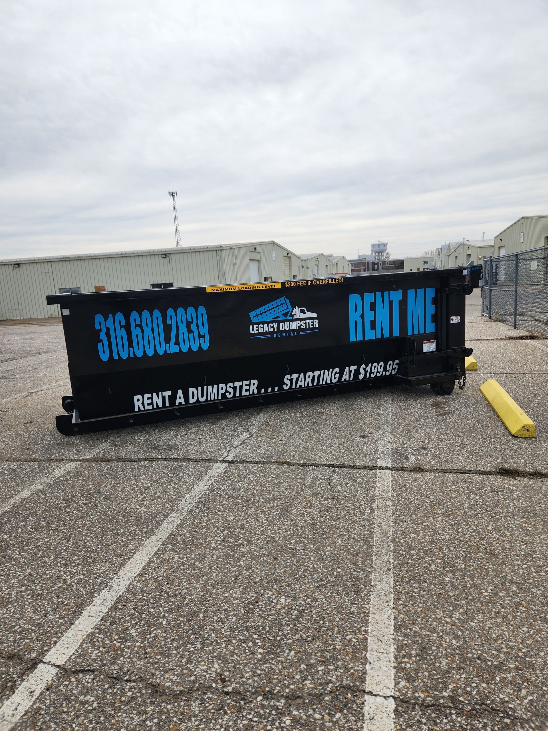 A dumpster is sitting on the ground in a parking lot.