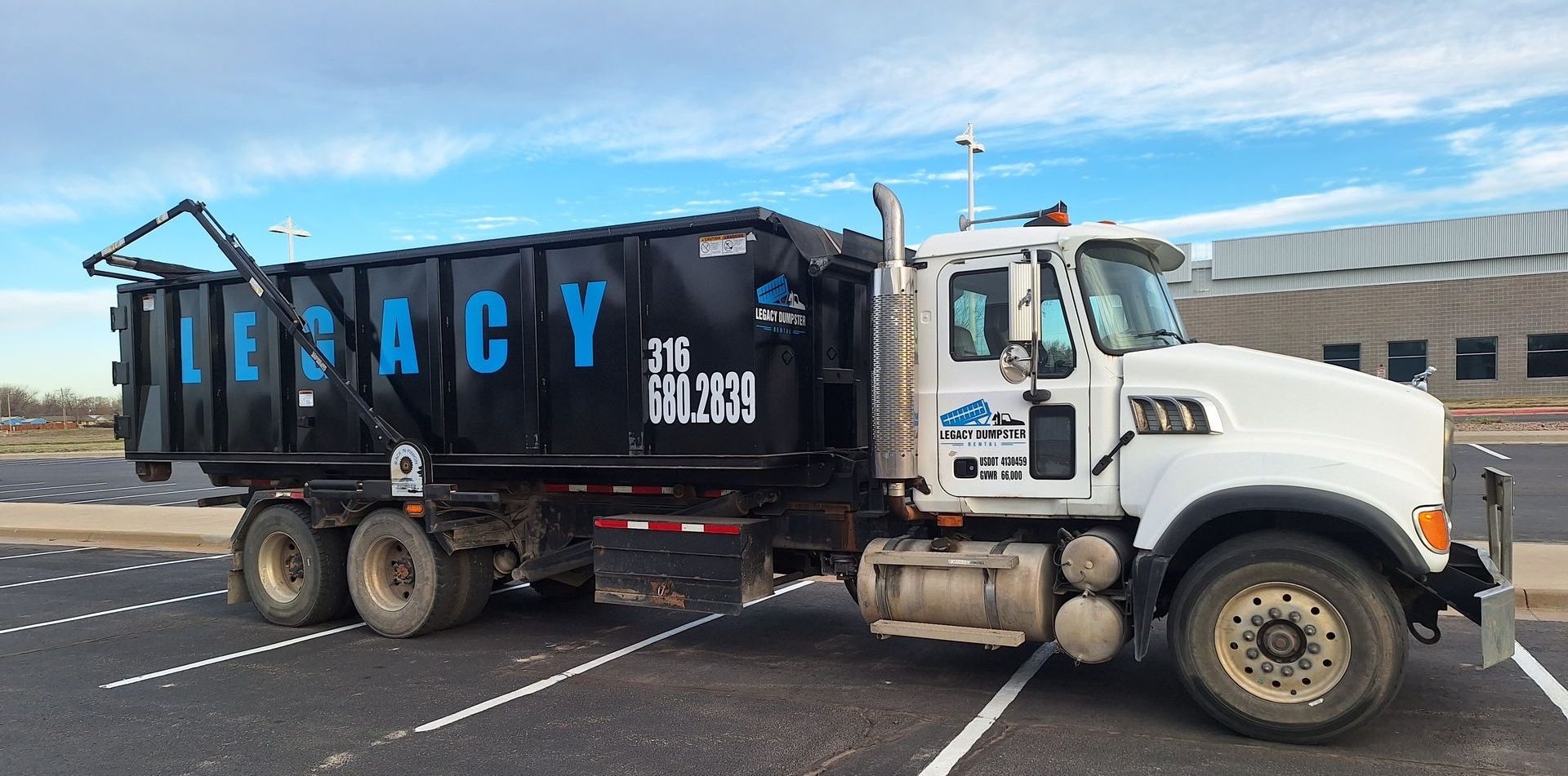 A dump truck is parked in a parking lot with a 40 yard dumpster on the back in wichita