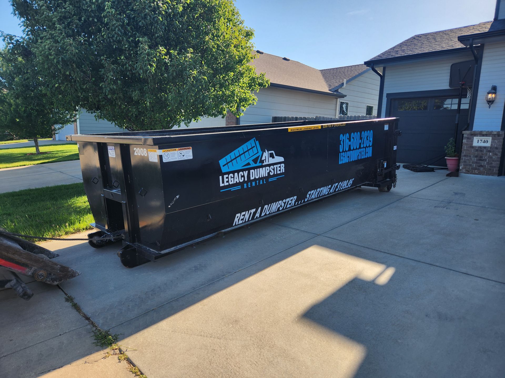 A 20 yard dumpster for rent is parked in front of a large commercial building