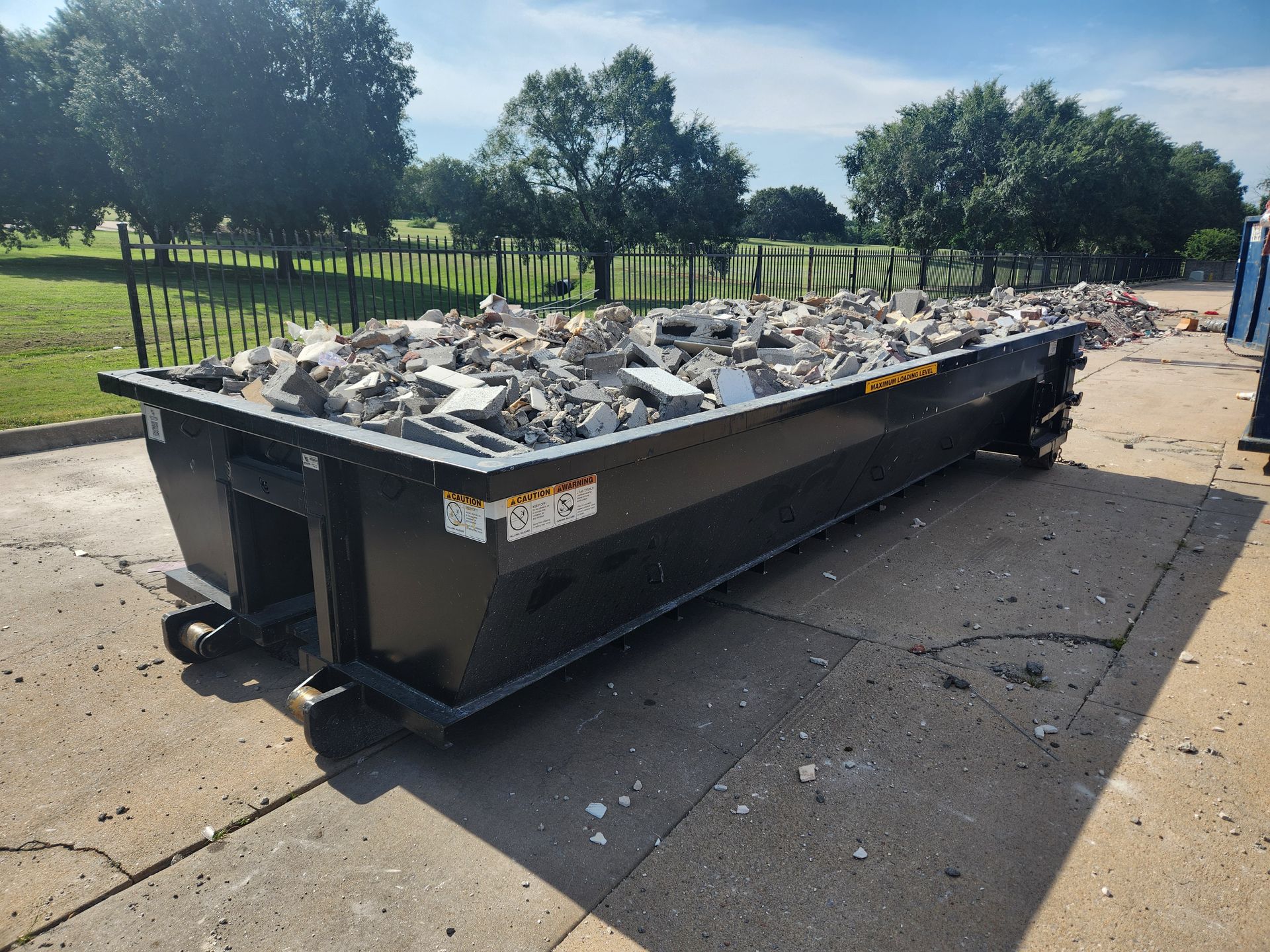 Concrete dumpster filled to the top with broken concrete