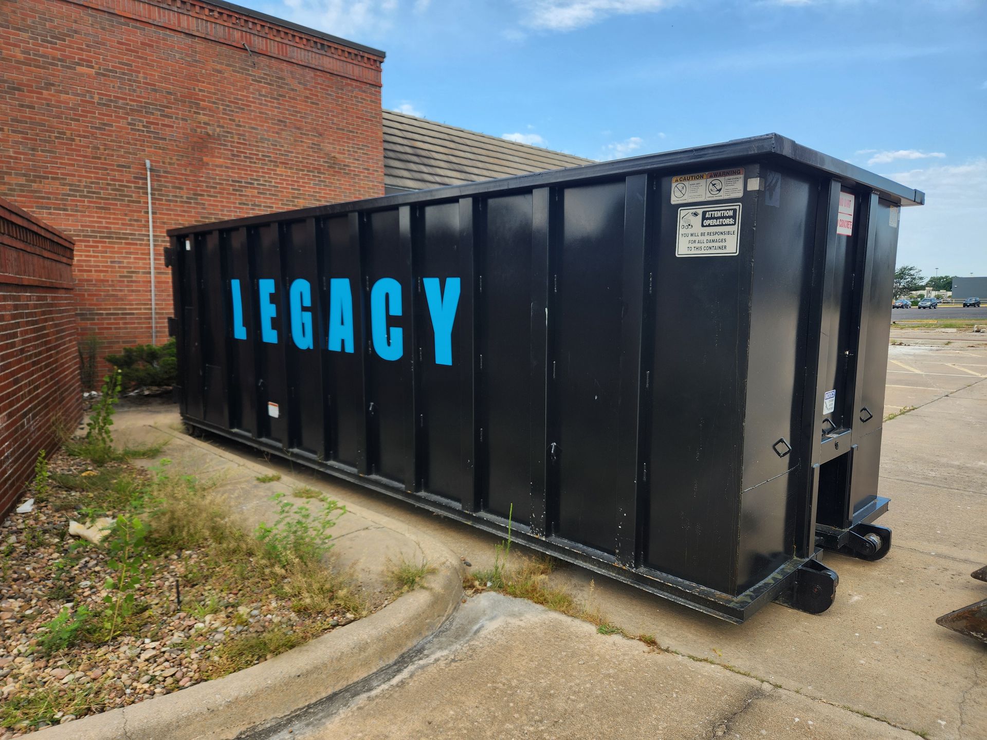 A dump truck is parked in a parking lot with a 40 yard dumpster on the back in wichita dumpster rentals