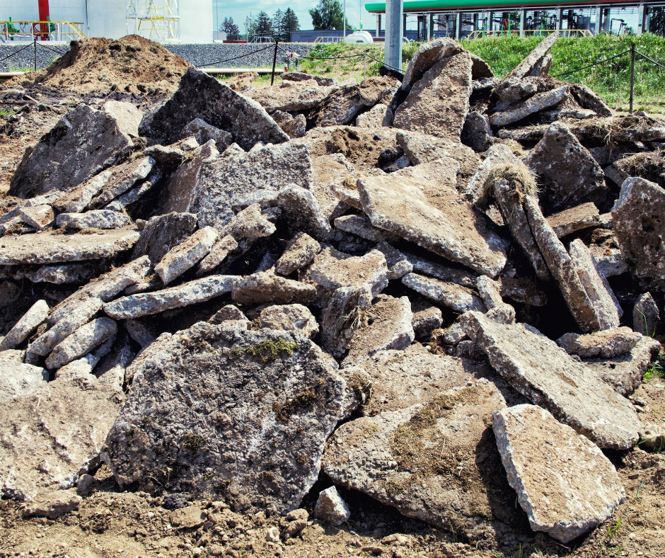 A pile of rocks is sitting in the dirt in a field.