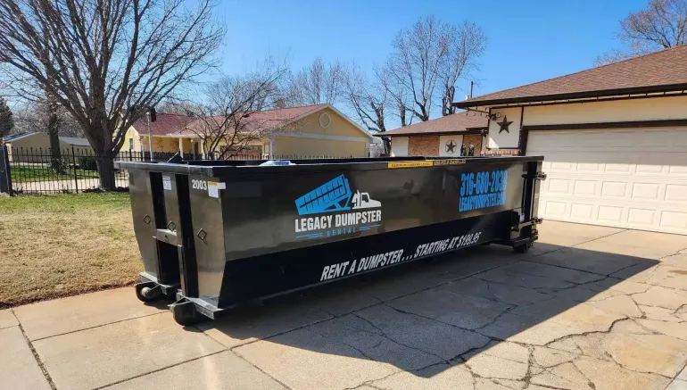 A 20 yard dumpster is parked in front of a house.