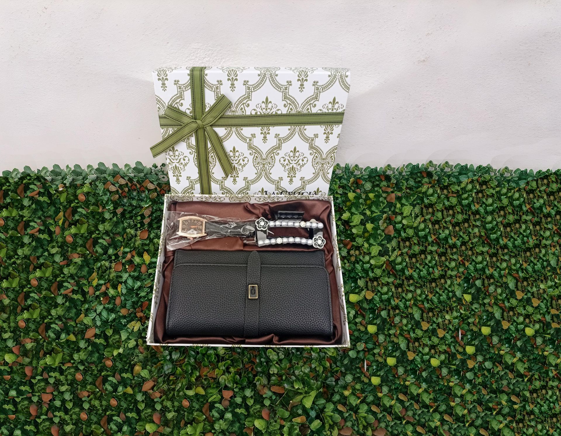 Una caja con una billetera y un reloj dentro.