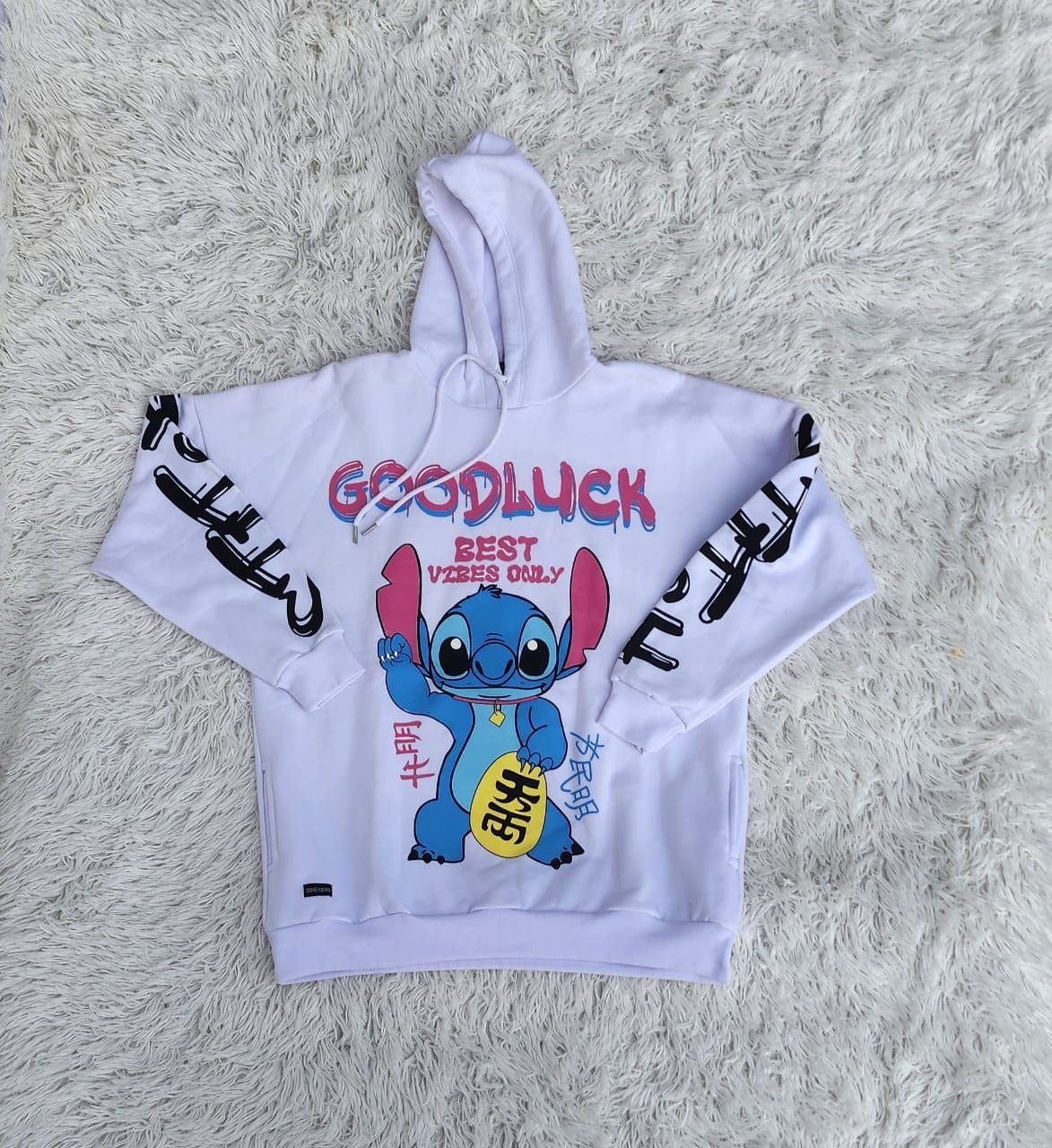 Una sudadera blanca con una costura que dice buena suerte.