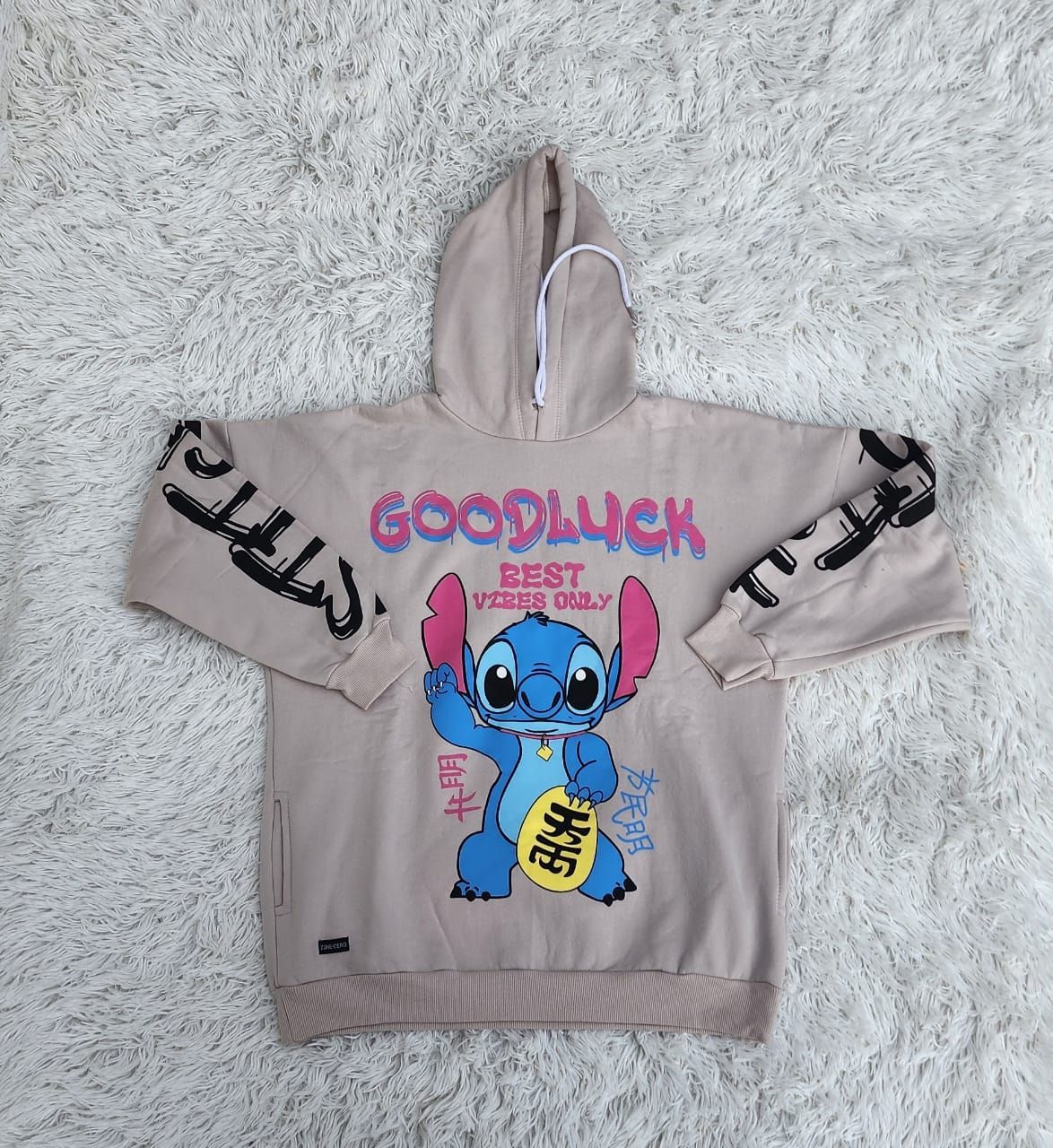 Una sudadera blanca con una costura que dice buena suerte.