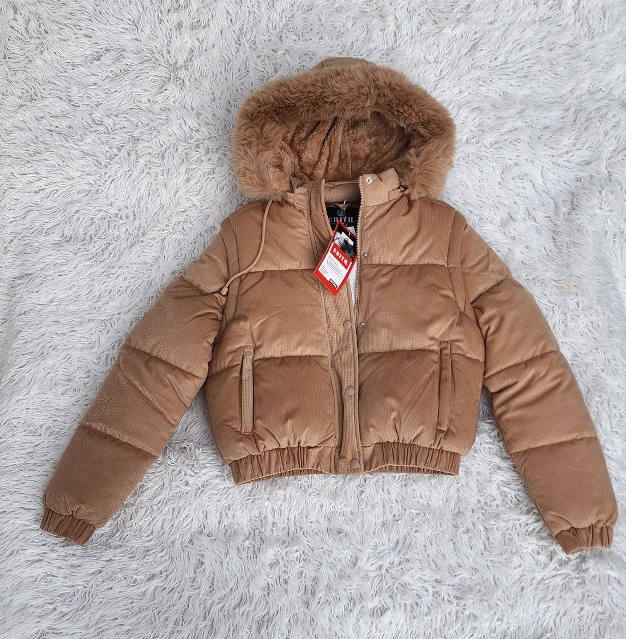 Una chaqueta acolchada marrón con capucha de piel