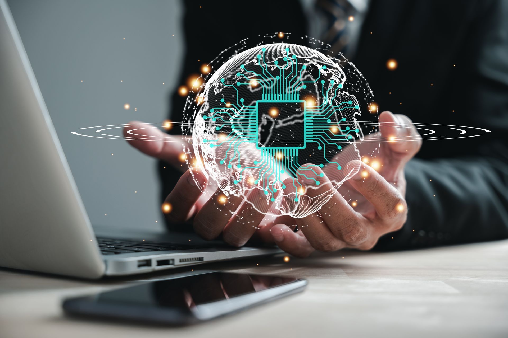 Un hombre sostiene un globo terráqueo en sus manos frente a una computadora portátil.