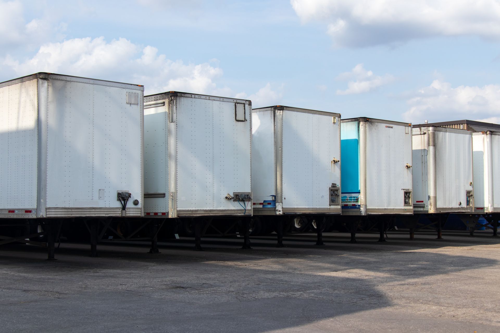 Moving truck backed up in front of a house, filled with cardboard boxes, ready to be unloaded.