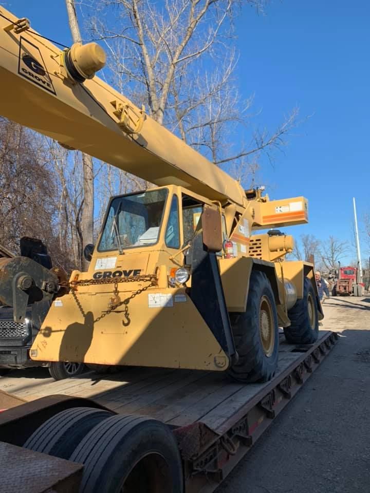 A large yellow crane is sitting on top of a trailer.