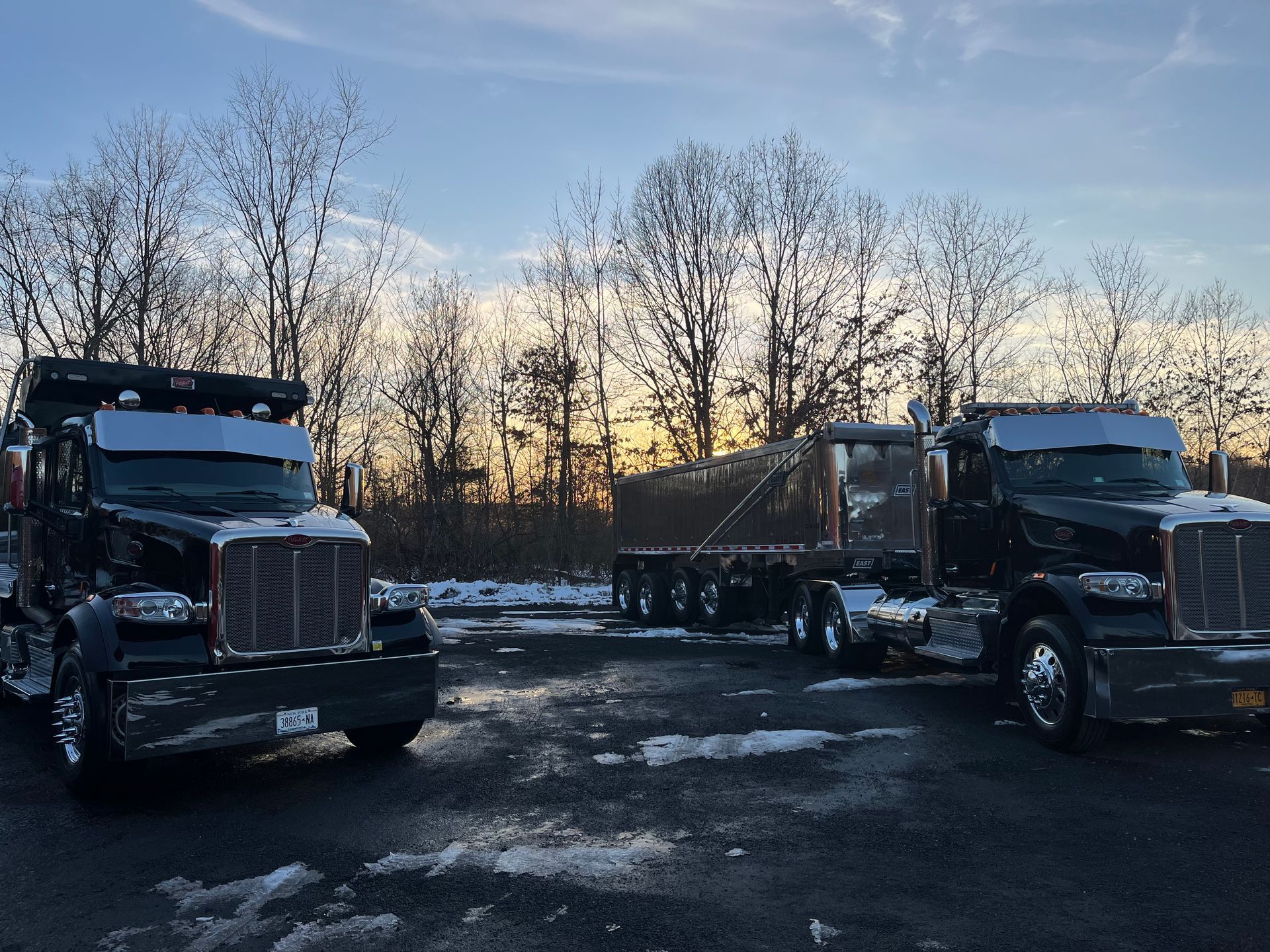 Two semi trucks are parked next to each other in a parking lot.