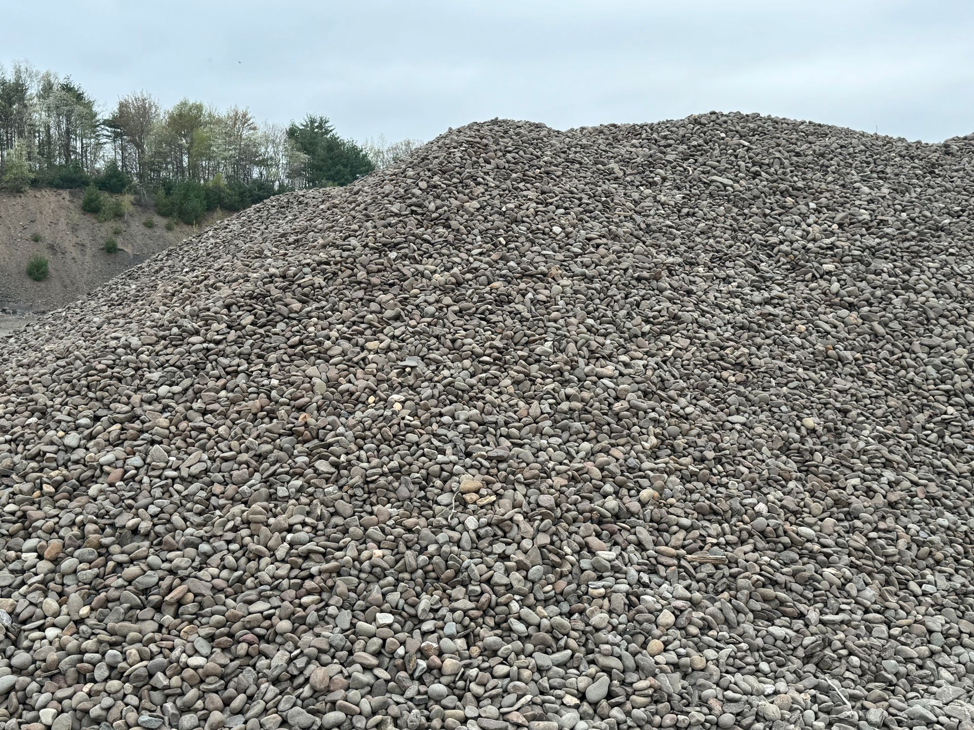 A large pile of gravel is sitting on top of a hill.