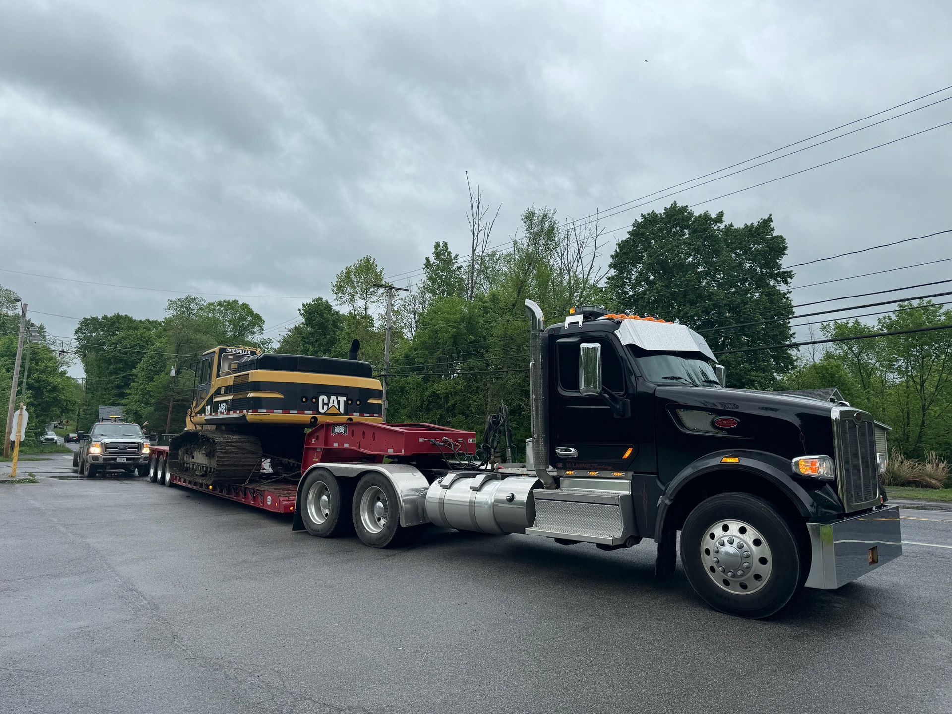 A semi truck is carrying a large excavator on a trailer.