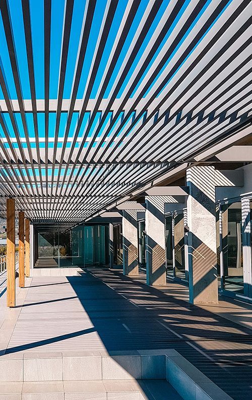 pergola with slats to allow sunlight in onto concrete outdoor space