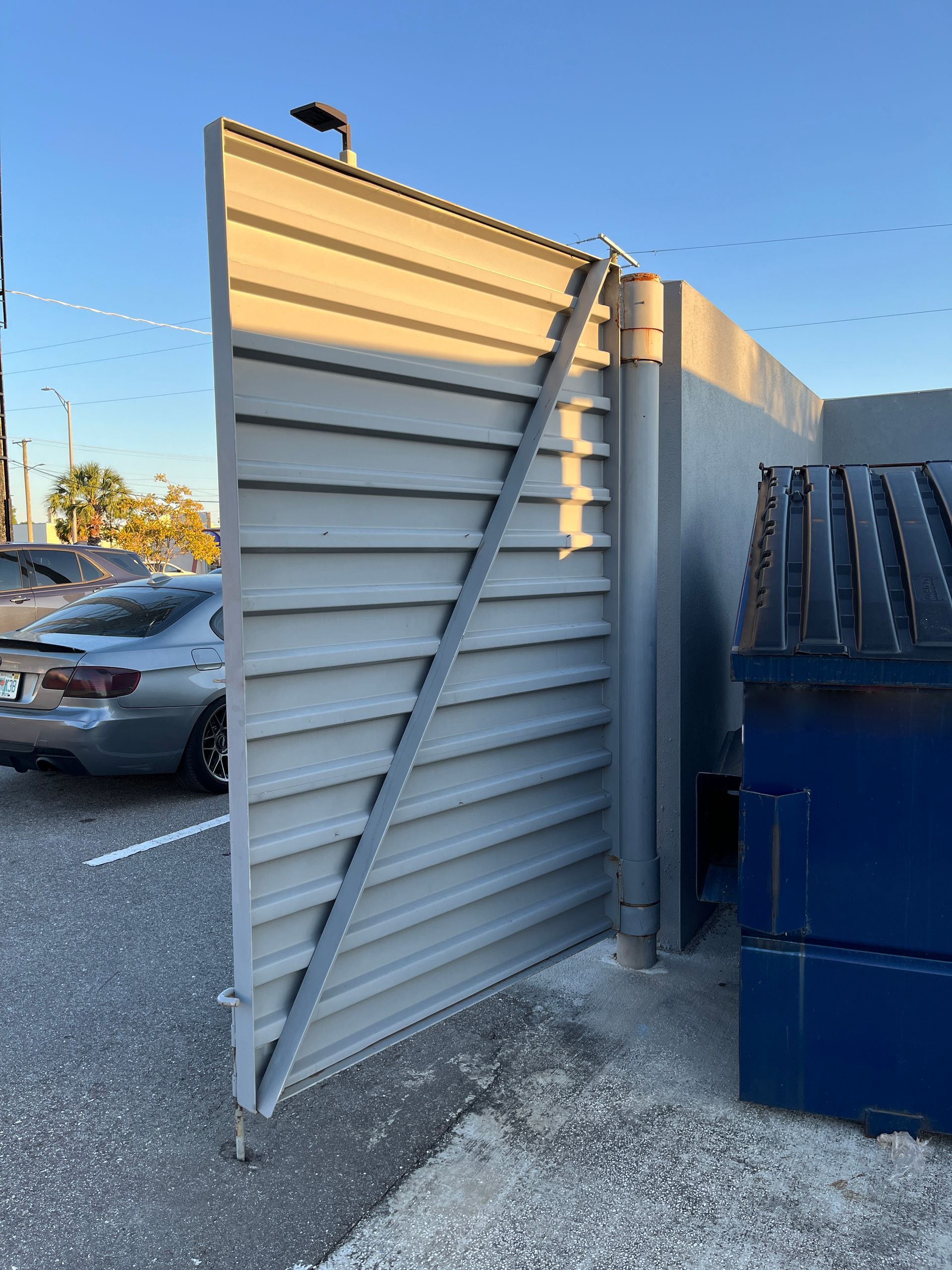 double door dumpster gate in Tampa parking lot on metal hinges