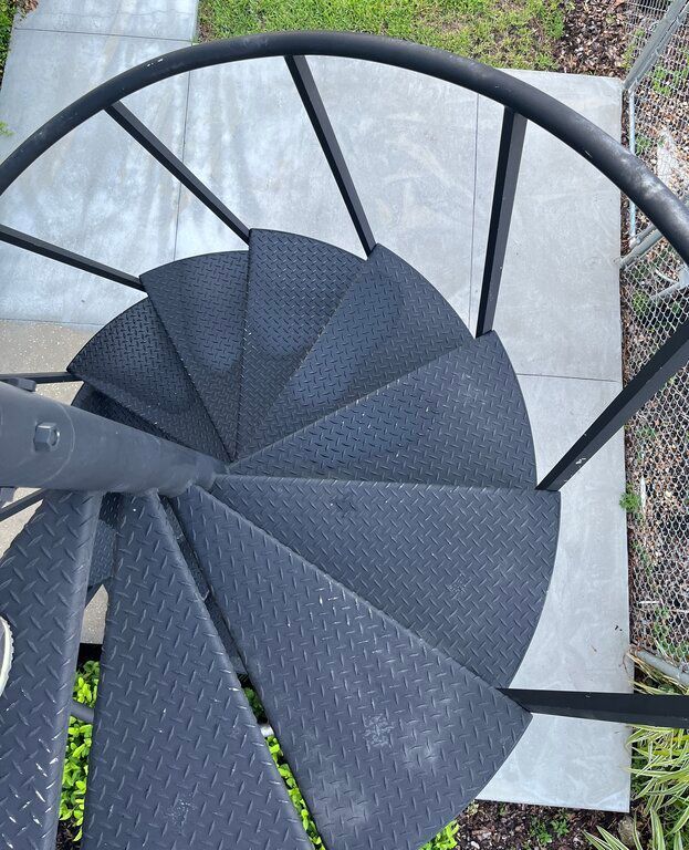 stainless steel grid on treads of black helical stairs