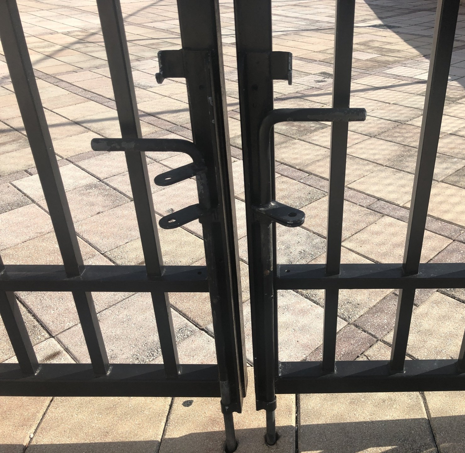 steel walk-through gate installed on the pavers, featuring added lock poles