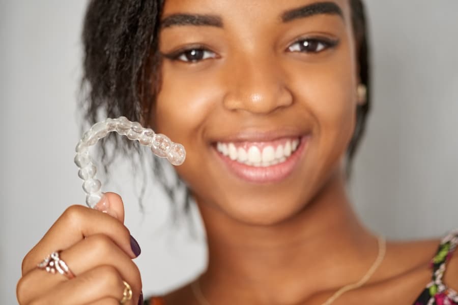 Smiling girl holding Invisalign