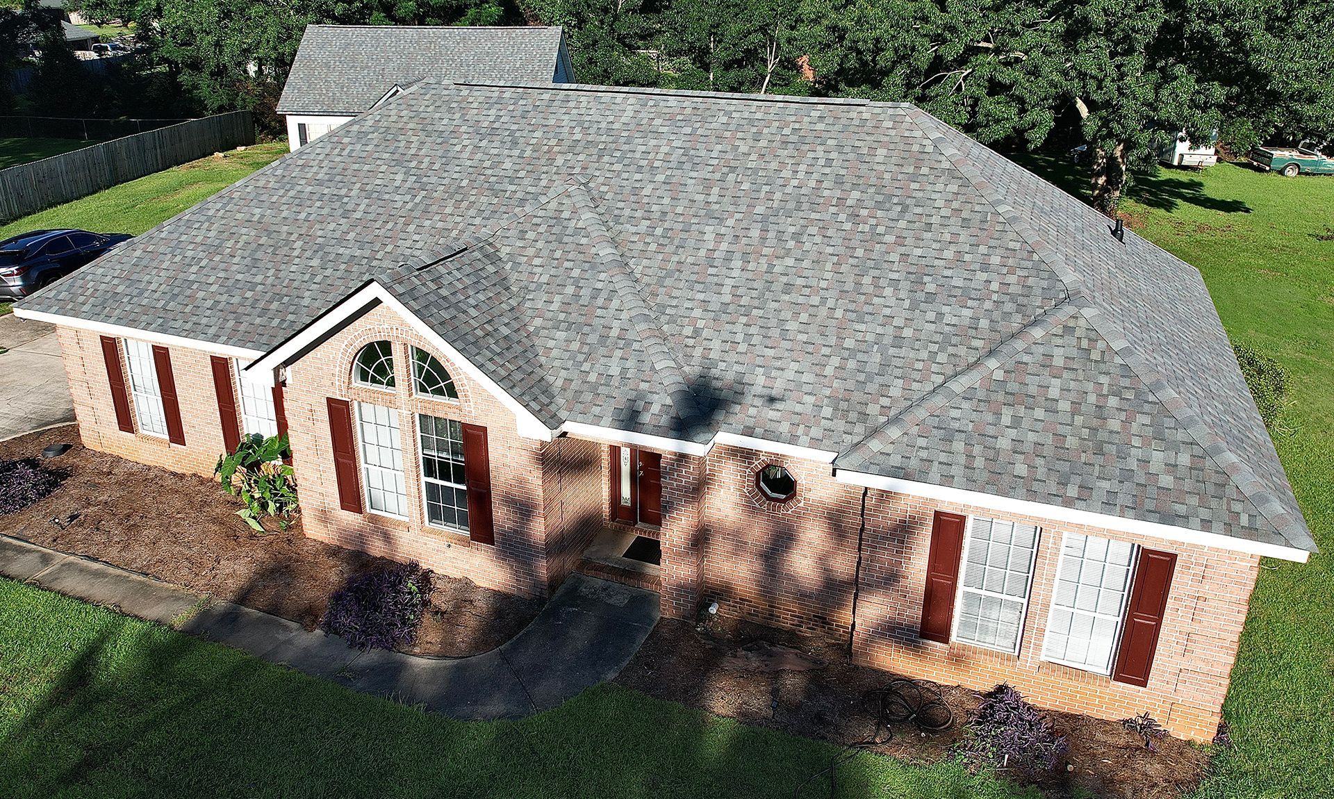 Experienced roofers installing shingles on residential roof