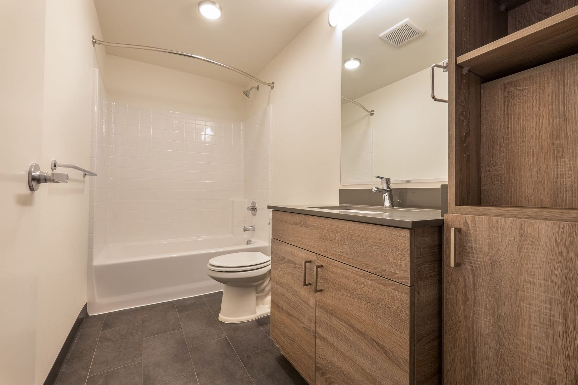 A bathroom with a toilet , sink , and bathtub at CREW Apartments in Seattle, WA.