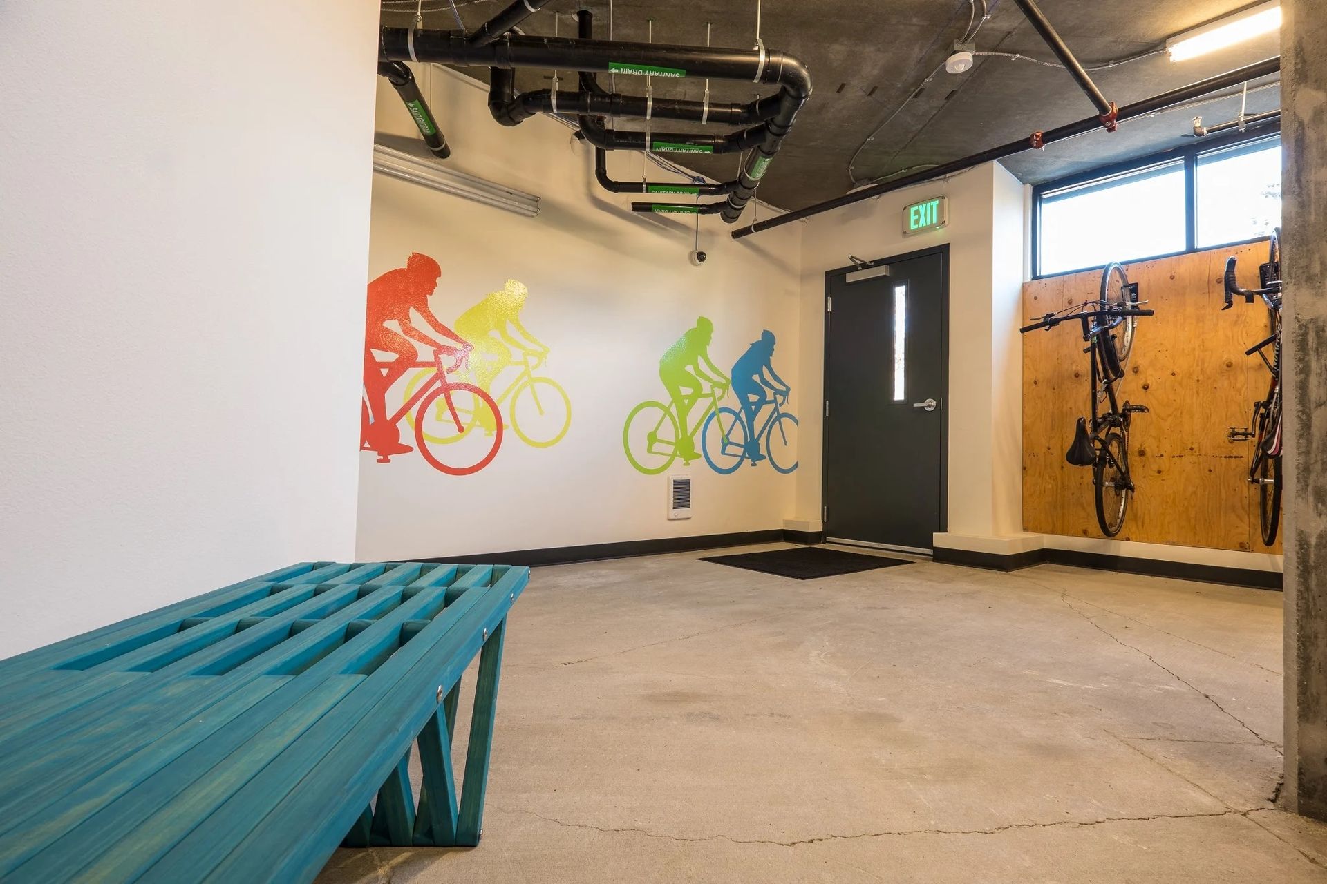 A room with a bench and bicycles on the wall at CREW Apartments in Seattle, WA.